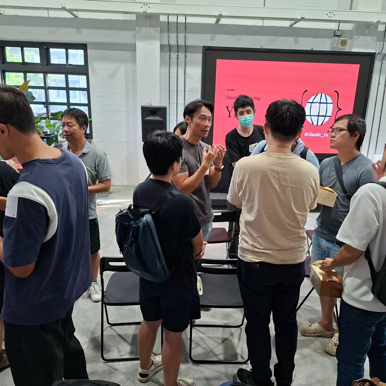 會後我在大螢幕前跟一群人比手畫腳地聊