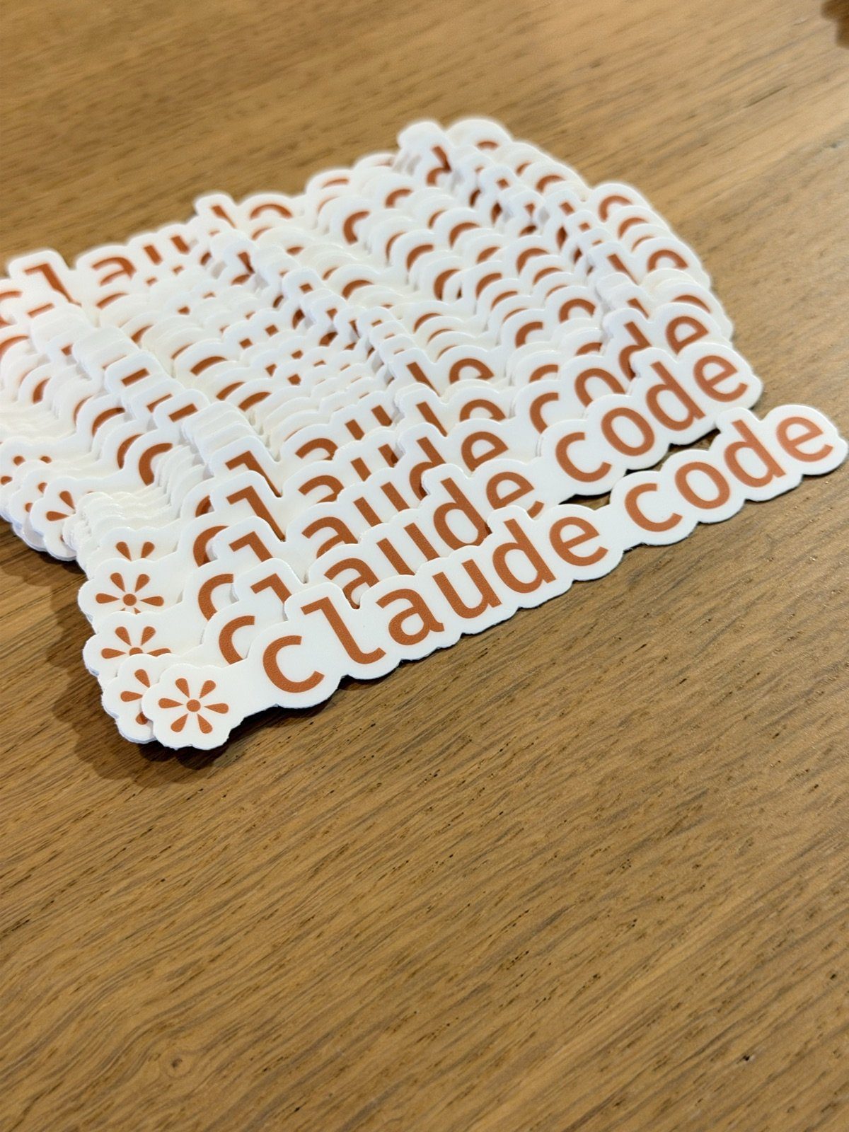 木桌上一疊「claude code」字樣的貼紙